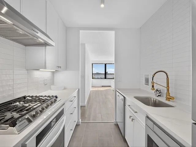 a kitchen with white cabinets and appliances