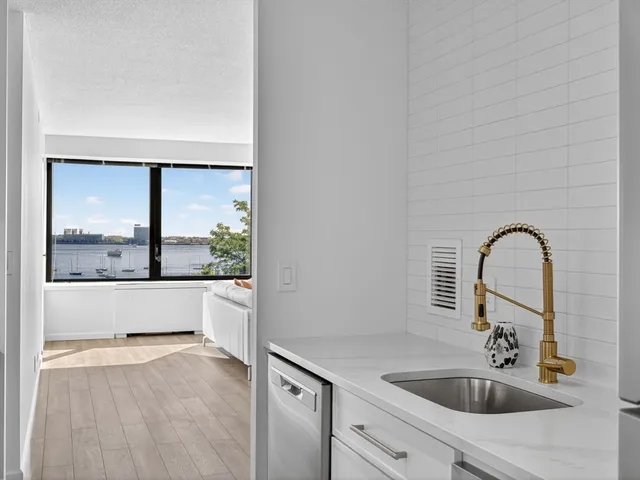 a bathroom with a sink and a large mirror next to a window