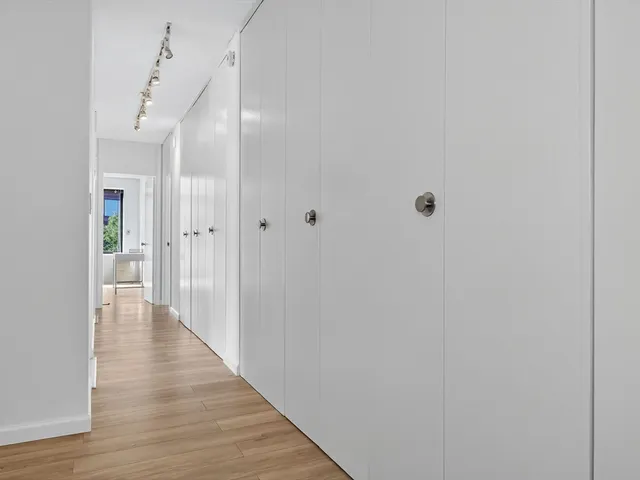 a view of a hallway with wooden floor