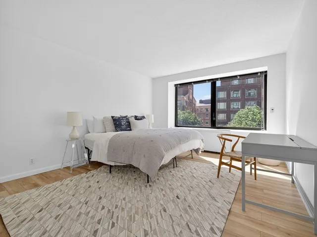 a bedroom with a bed and a large window