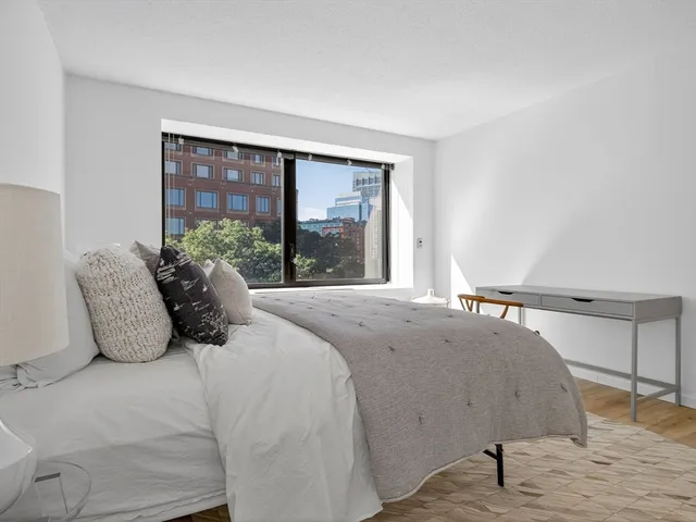 a large bed sitting in a bedroom next to a window