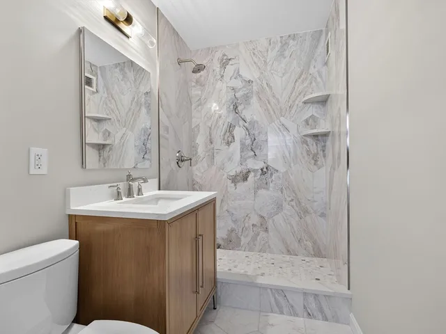 a bathroom with a sink a toilet and shower