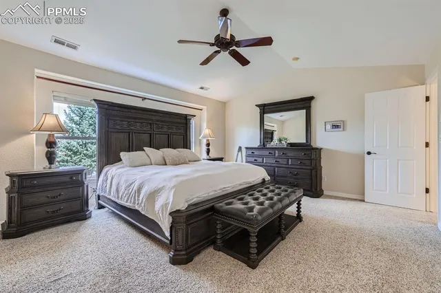 a bedroom with a bed a dresser and a chandelier