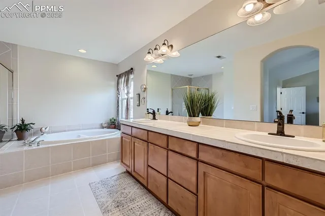 a bathroom with a tub double sink and a mirror