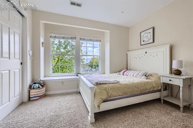 a bed sitting in a bedroom next to a window