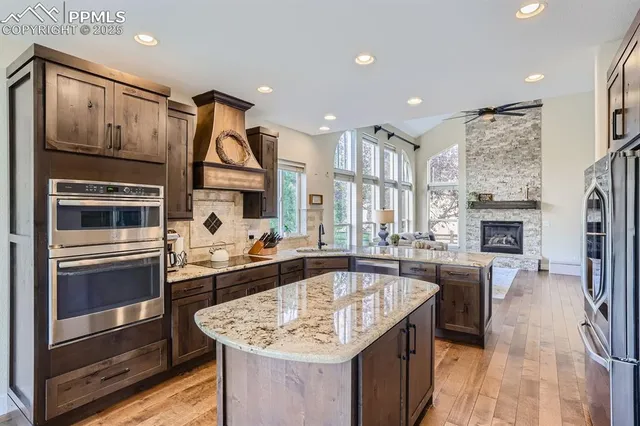a kitchen with stainless steel appliances granite countertop a sink stove and refrigerator