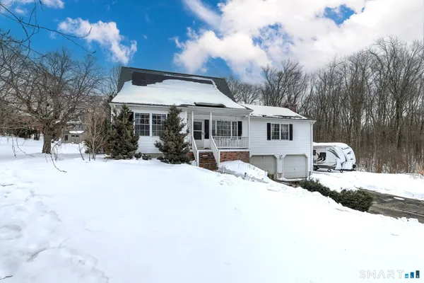 a front view of a house with a yard covered in snow
