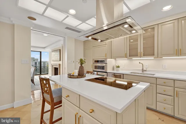 a kitchen that has a sink and chairs