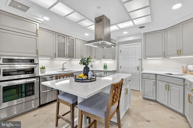 a kitchen with kitchen island a stove a table and chairs in it