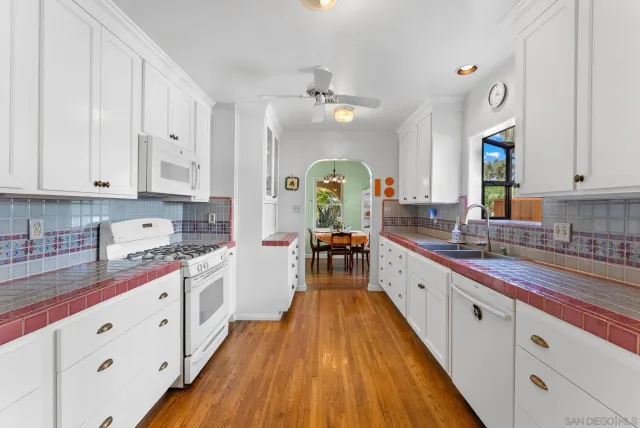 a large kitchen with stainless steel appliances granite countertop a lot of counter space and wooden floors