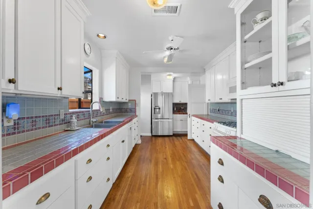 a large kitchen with stainless steel appliances granite countertop a lot of counter space and wooden floors