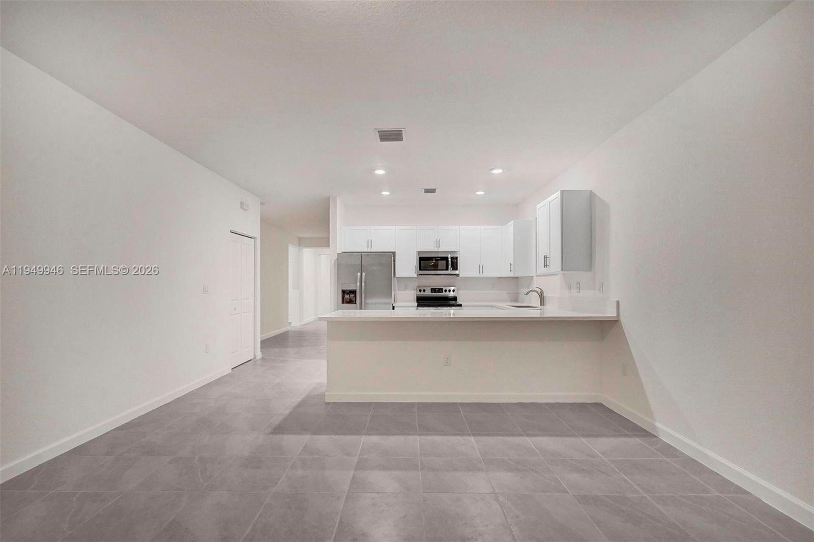 13405 Southwest 285th Street Homestead, FL 33033 - Photo 52 of 59 a large white kitchen with kitchen island a sink stainless steel appliances and a counter top