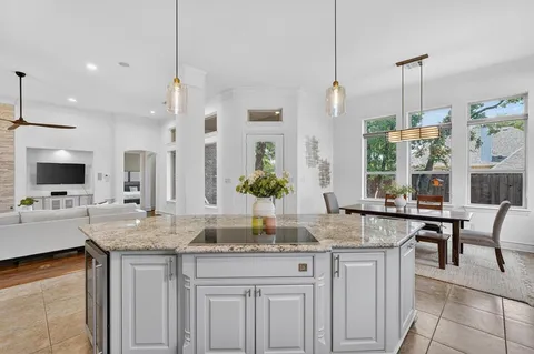 a kitchen with granite countertop a sink and white cabinets