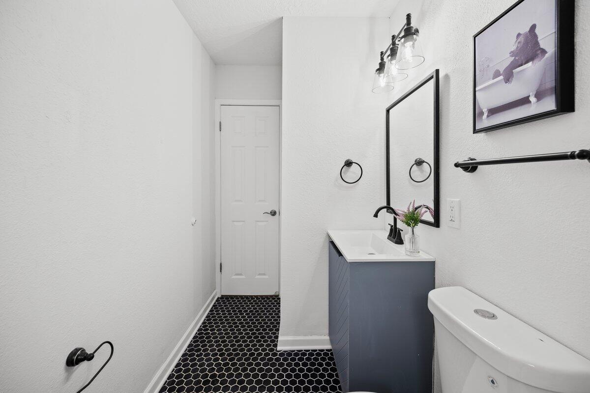 4352 Watkins Street Pace, FL 32571 - Photo 16 of 24 a bathroom with a sink toilet and mirror