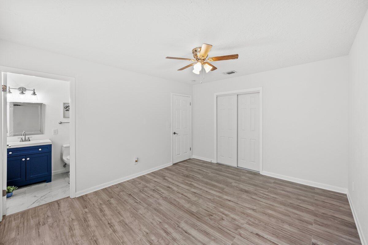 4352 Watkins Street Pace, FL 32571 - Photo 18 of 24 a view of empty room with wooden floor and fan