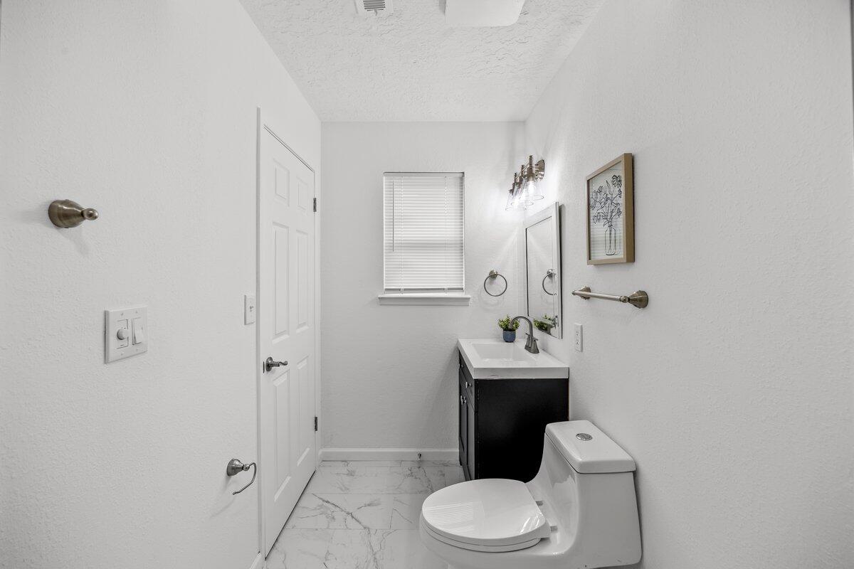 4352 Watkins Street Pace, FL 32571 - Photo 21 of 24 a white toilet sitting next to a bathroom sink
