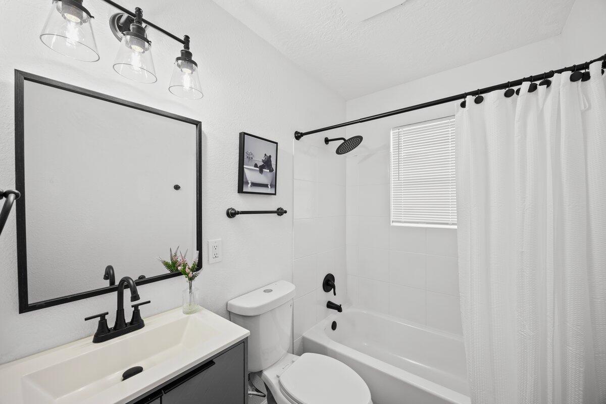 4352 Watkins Street Pace, FL 32571 - Photo 3 of 24 a bathroom with a sink toilet a mirror and shower