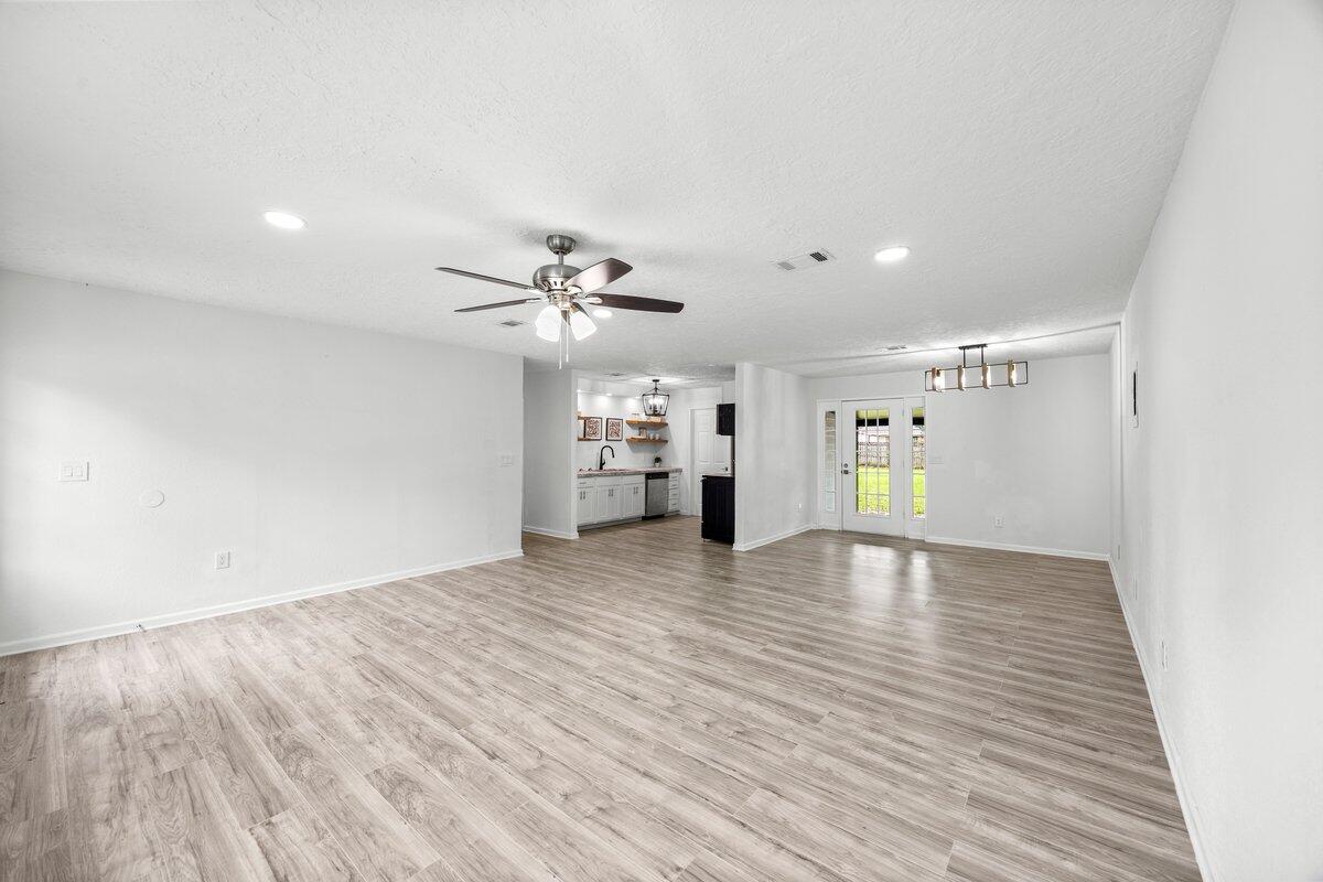 4352 Watkins Street Pace, FL 32571 - Photo 8 of 24 a view of empty room with wooden floor and ceiling fan