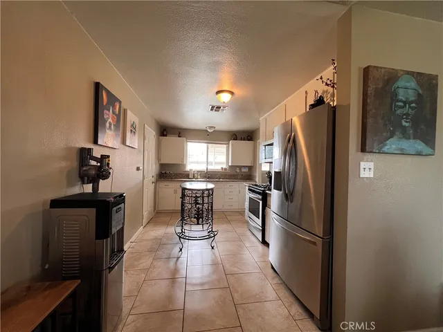 a kitchen with stainless steel appliances granite countertop a refrigerator and a stove top oven