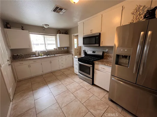 a kitchen with stainless steel appliances granite countertop a refrigerator sink and stove