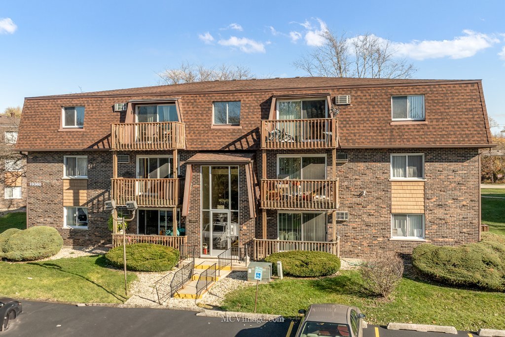 19360 Wolf Road, Unit 10 Mokena, IL 60448 - Photo 1 of 24 a view of a white house with large windows and plants