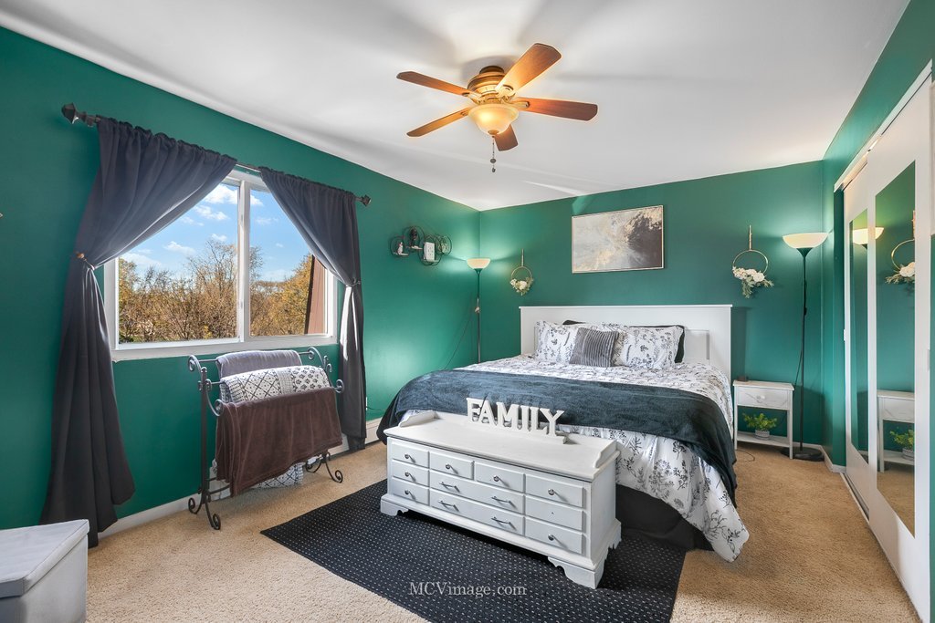 19360 Wolf Road, Unit 10 Mokena, IL 60448 - Photo 14 of 24 a bedroom with a bed chandelier and a large window