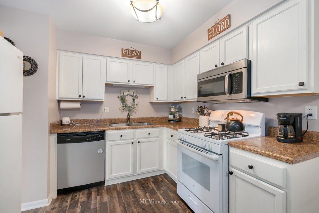 19360 Wolf Road, Unit 10 Mokena, IL 60448 - Photo 8 of 24 a white kitchen with granite countertop stainless steel appliances