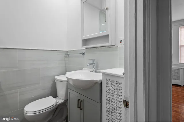 a bathroom with a toilet a sink and mirror