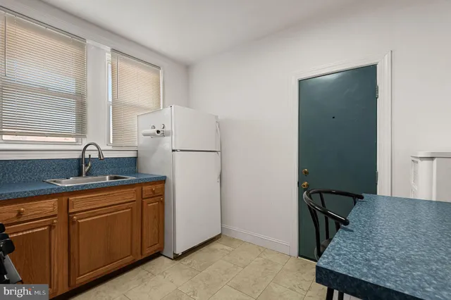 a kitchen with a granite countertop sink stove and refrigerator