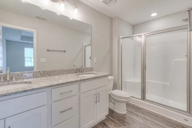 a bathroom with a granite countertop sink toilet and shower