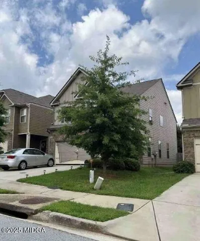 a front view of a house with a garden