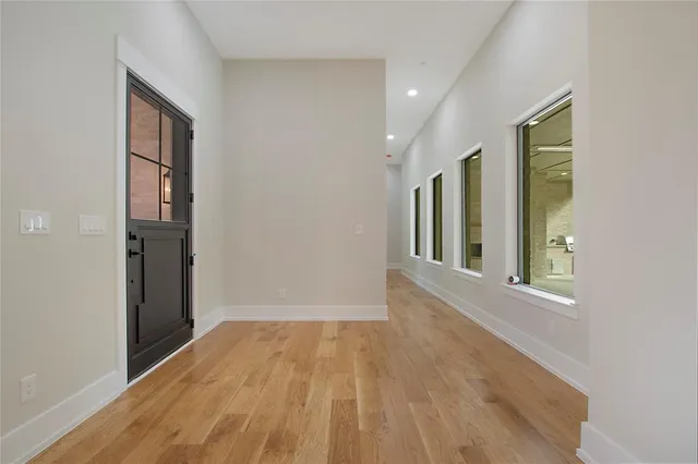a view of hallway with livingroom and wooden floor