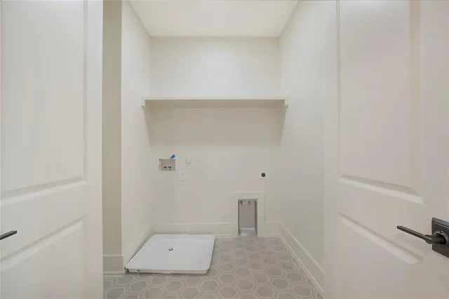 an empty room with wooden floor closet and windows
