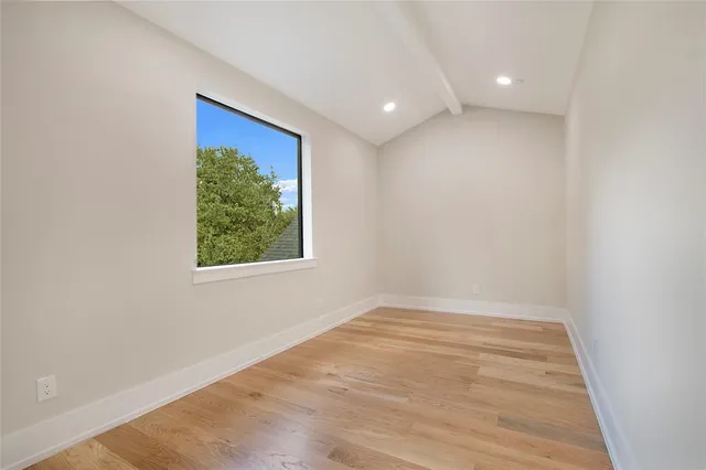 a view of an empty room with a fireplace and a window