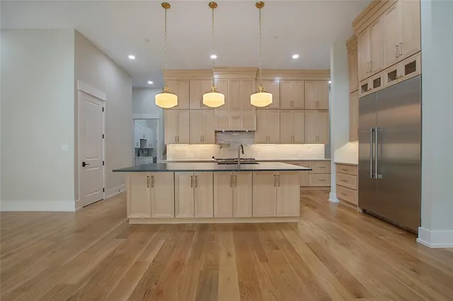 a large kitchen with kitchen island a sink stainless steel appliances and cabinets