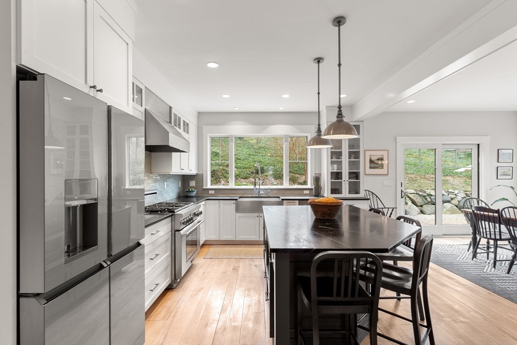 7 Bradlee Road Marblehead, MA 01945 - Photo 6 of 41 a kitchen with stainless steel appliances granite countertop a stove a refrigerator a kitchen island a table and chairs