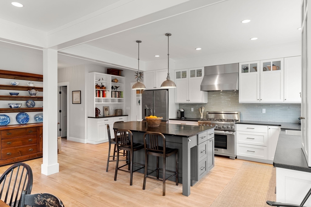 7 Bradlee Road Marblehead, MA 01945 - Photo 8 of 41 a kitchen with stainless steel appliances granite countertop a stove top oven a refrigerator a sink and a dining table with wooden floor