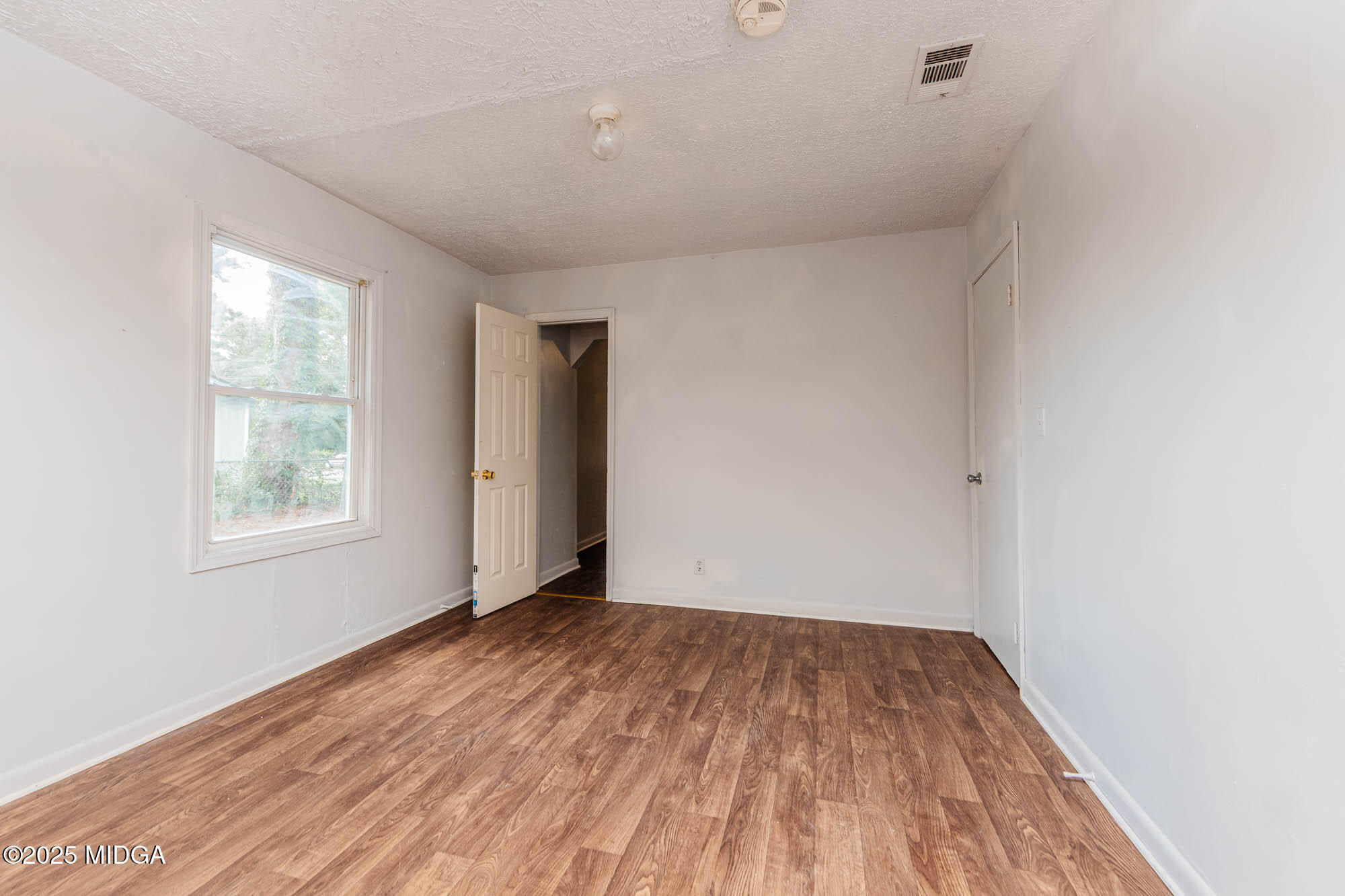 125 Suzanne Drive Warner Robins, GA 31093 - Photo 17 of 50 an empty room with wooden floor and windows