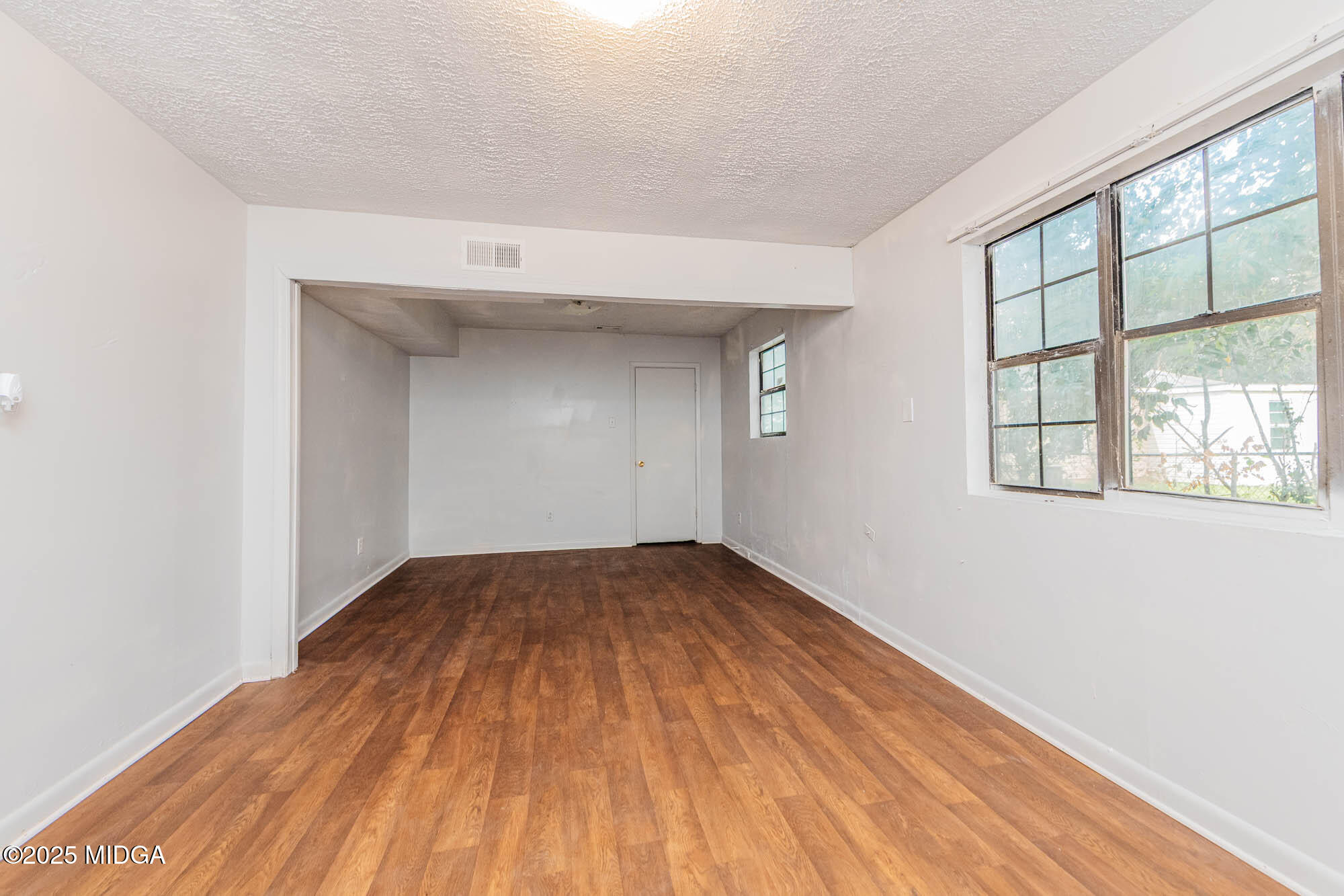 125 Suzanne Drive Warner Robins, GA 31093 - Photo 30 of 50 an empty room with wooden floor and windows