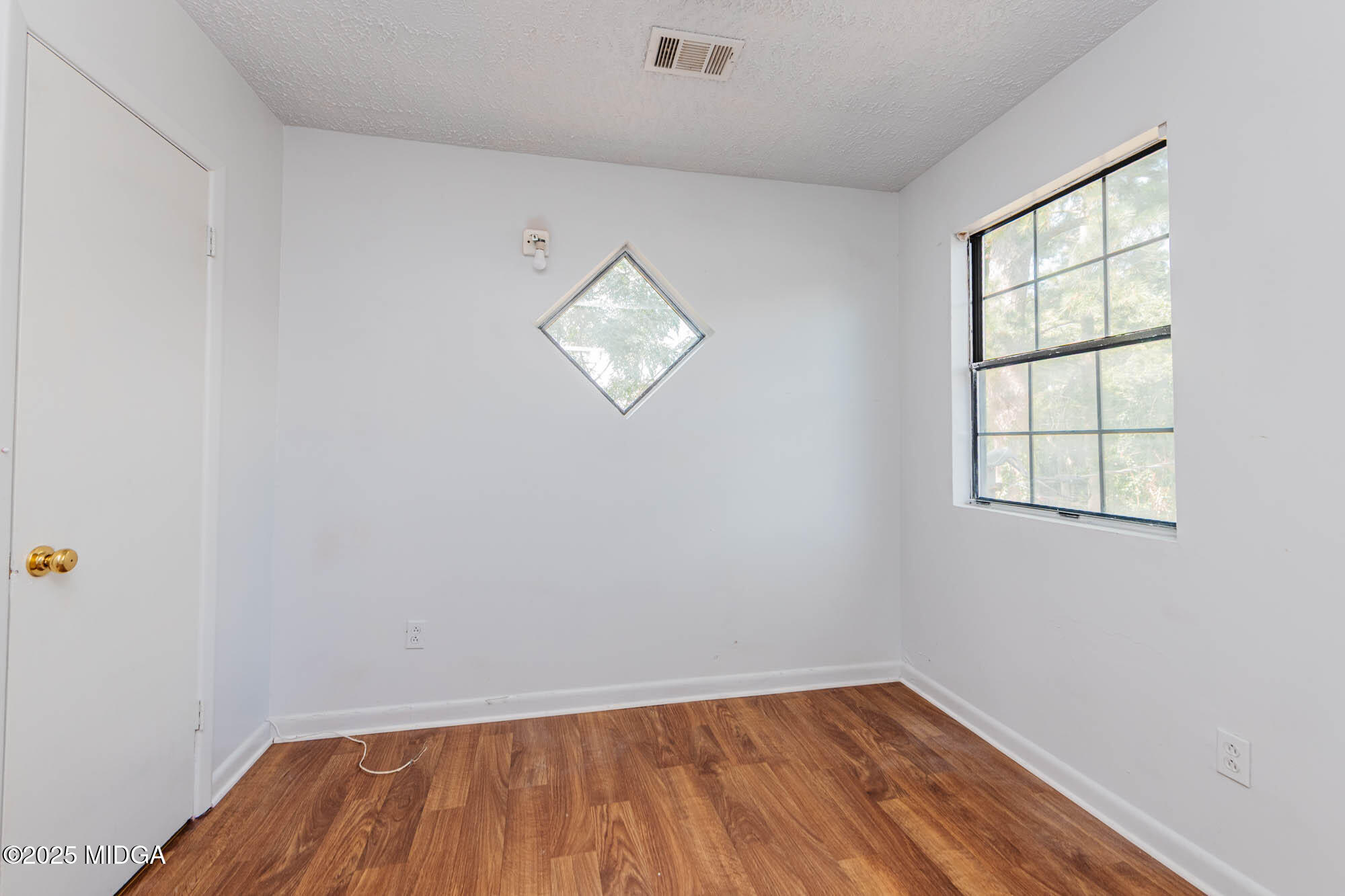 125 Suzanne Drive Warner Robins, GA 31093 - Photo 32 of 50 an empty room with wooden floor and windows