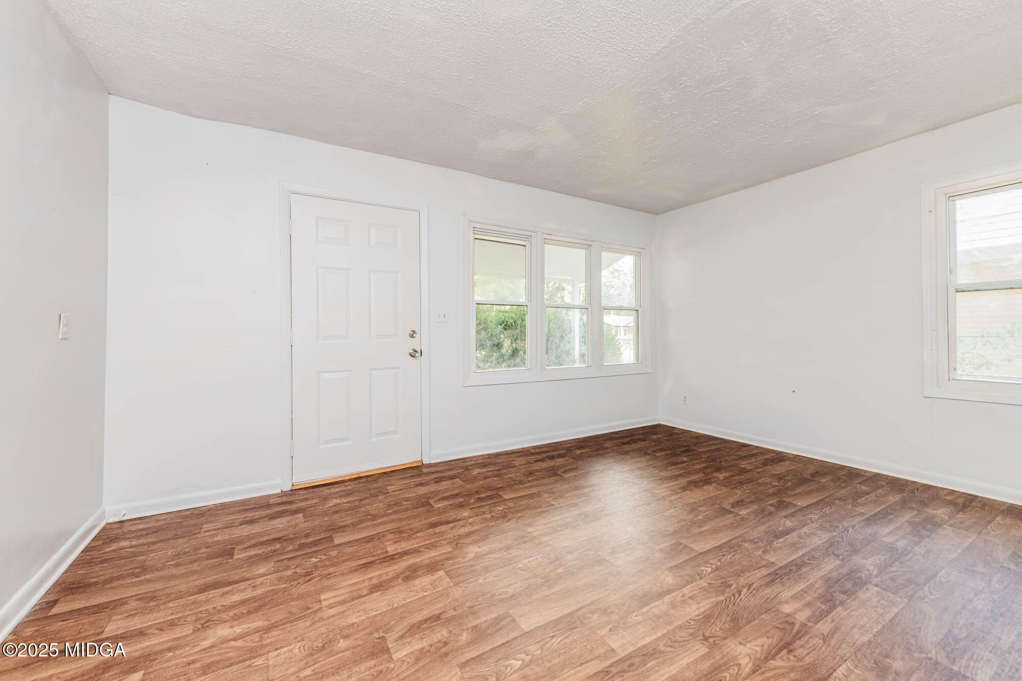 125 Suzanne Drive Warner Robins, GA 31093 - Photo 7 of 50 an empty room with wooden floor and windows
