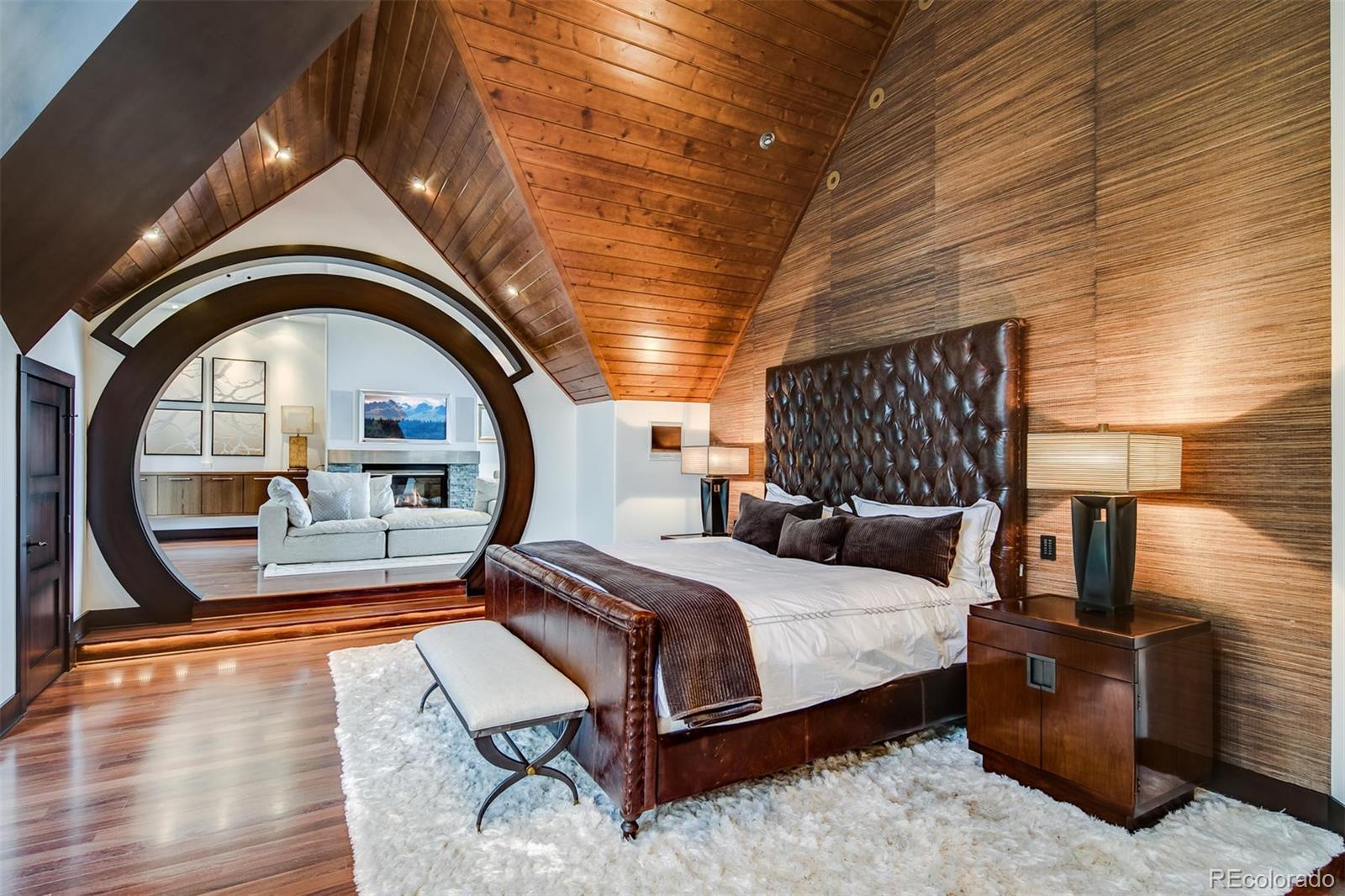 6917 Timbers Drive Evergreen, CO 80439 - Photo 16 of 39 a bedroom with a bed a mirror and a flat tv screen on the dresser