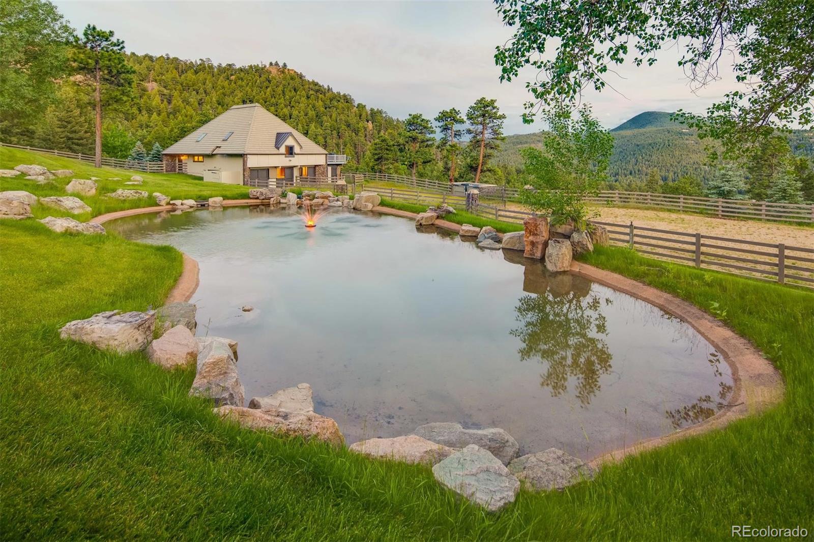 6917 Timbers Drive Evergreen, CO 80439 - Photo 26 of 39 an aerial view of a house with a yard and lake view