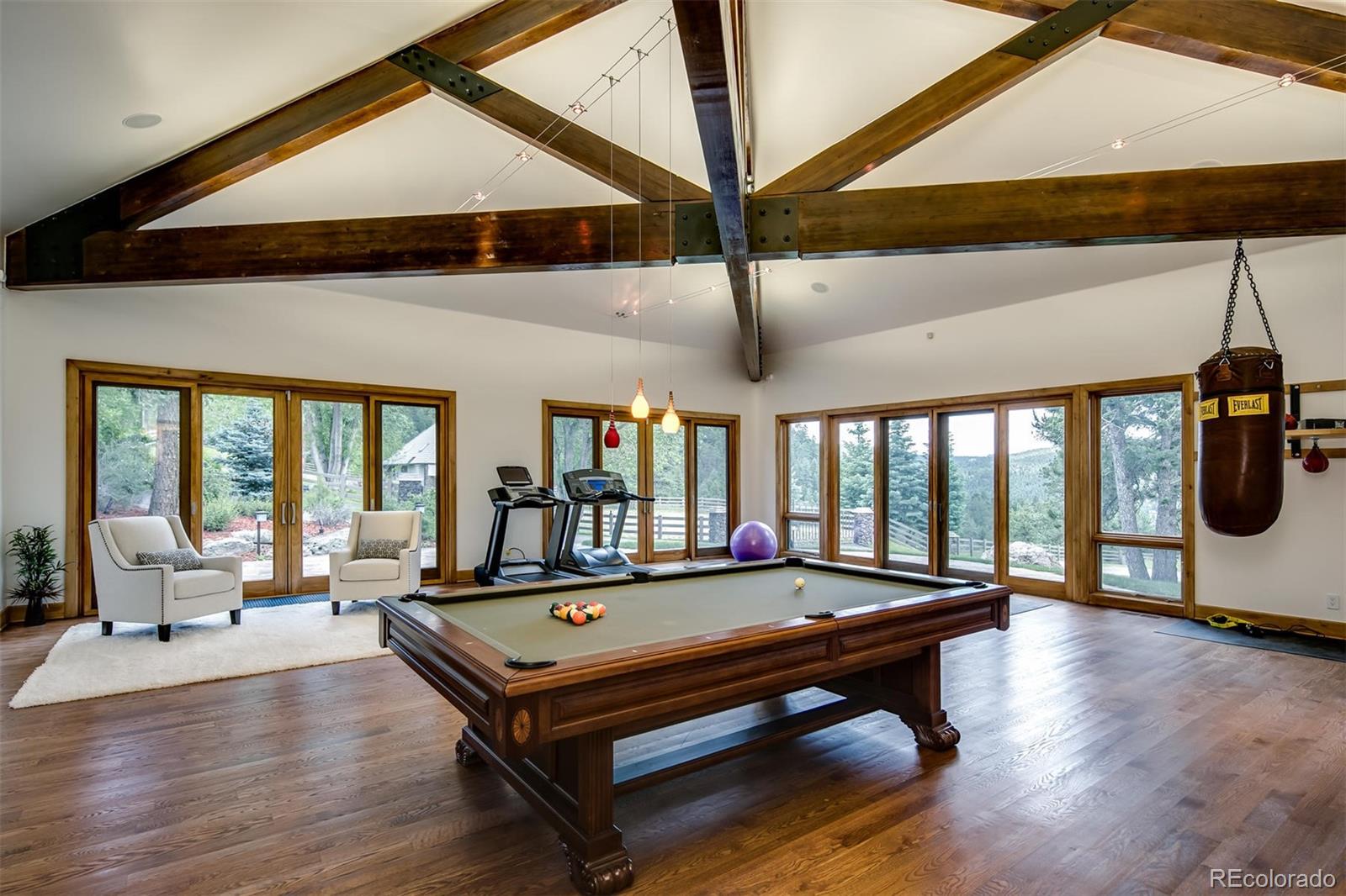 6917 Timbers Drive Evergreen, CO 80439 - Photo 33 of 39 a living room with a table chairs and a ceiling fan