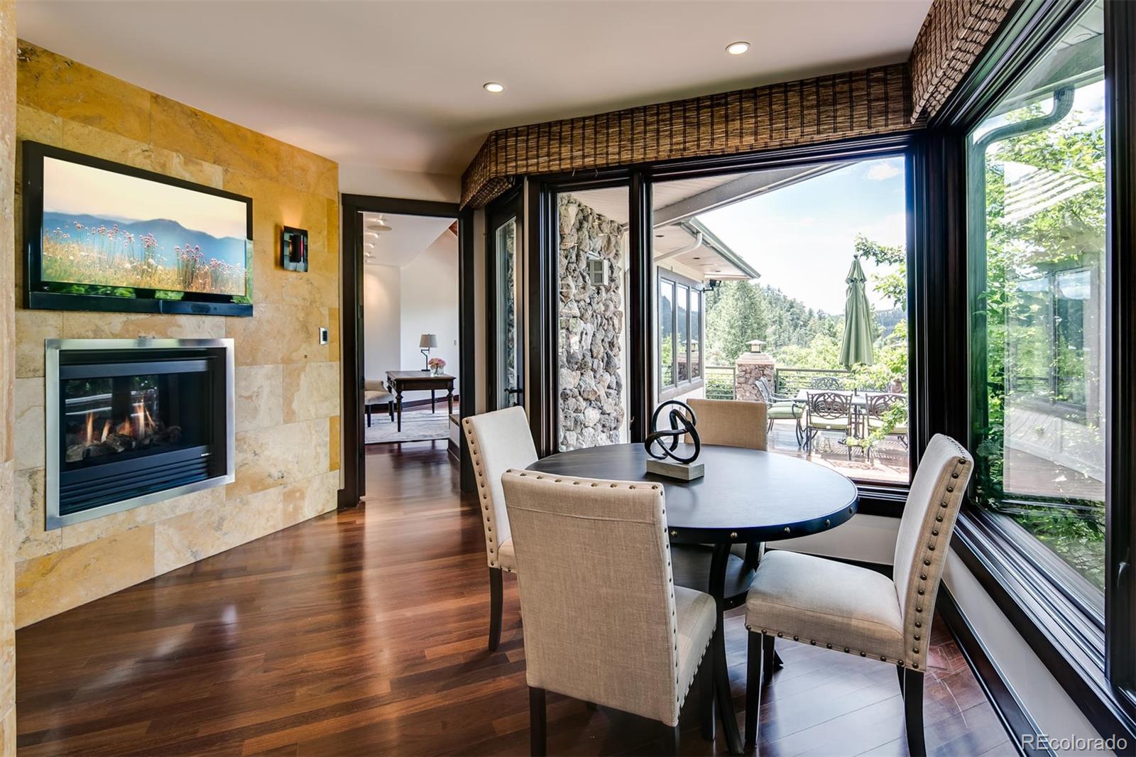6917 Timbers Drive Evergreen, CO 80439 - Photo 10 of 39 a dining room with furniture a fireplace and wooden floor