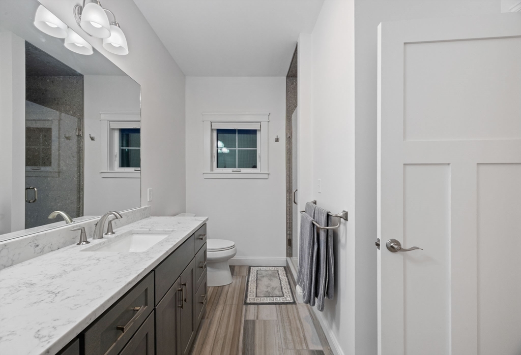 23 Starboard Drive, Unit 50 Wareham, MA 02532 - Photo 25 of 42 a bathroom with a granite countertop sink a toilet a mirror and shower