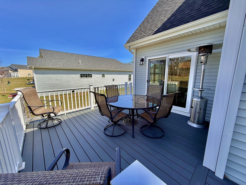 23 Starboard Drive, Unit 50 Wareham, MA 02532 - Photo 37 of 42 a view of a roof deck with table and chairs a barbeque with wooden floor and fence