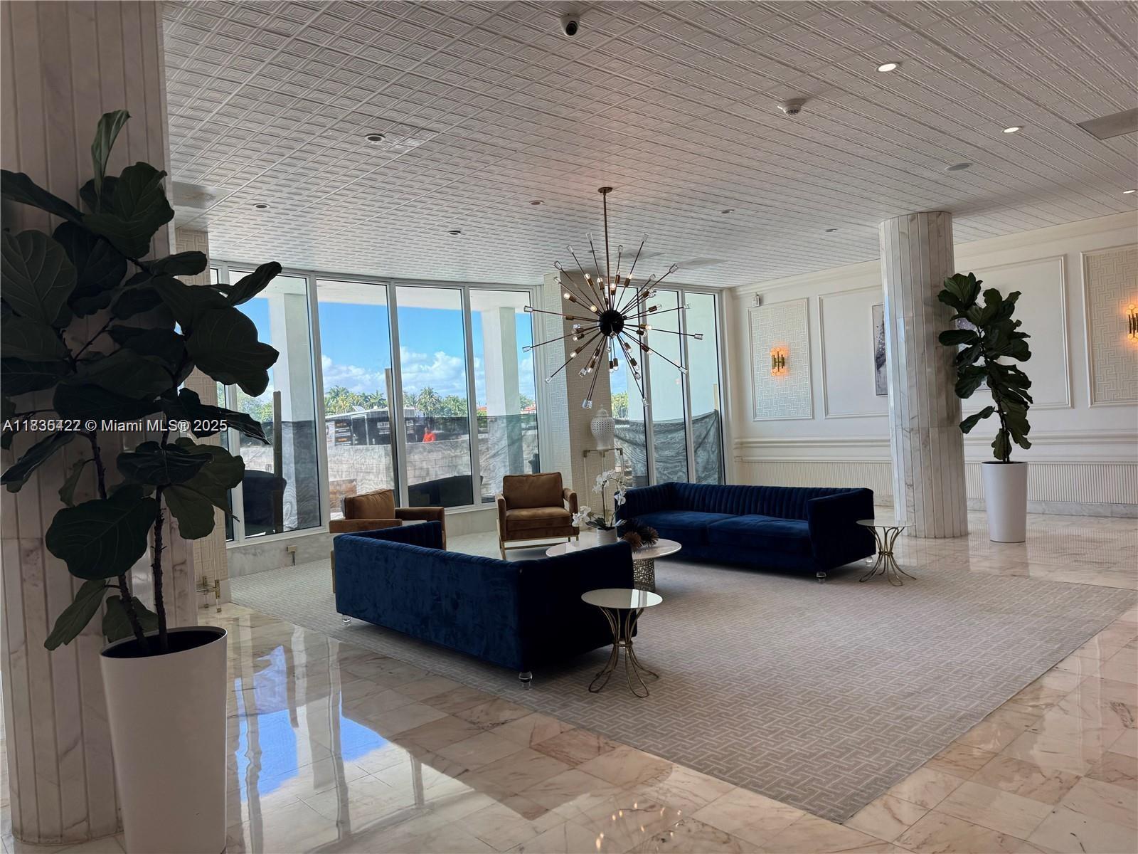 5750 Collins Avenue, Unit 4F Miami Beach, FL 33140 - Photo 15 of 46 a living room with furniture large window and flat screen tv