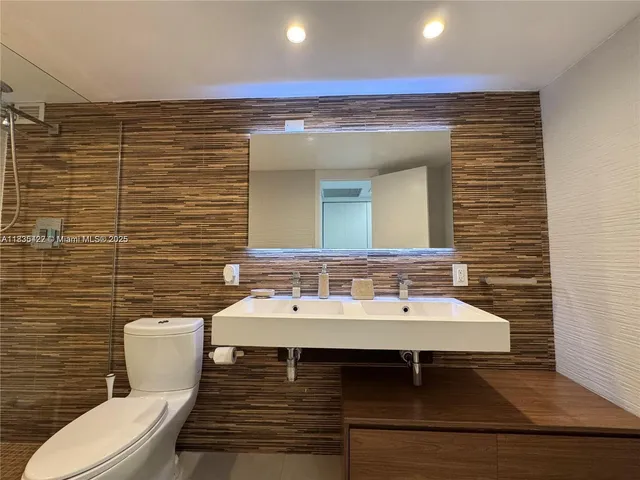 a bathroom with a sink a toilet and mirror
