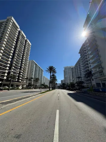 a city street with tall buildings in the background